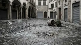Fermo di prevenzione a Milano: piazza del centro deserta all'alba con transenne rovesciate e serrande abbassate dopo i disordini
