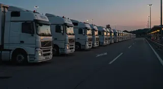 Sciopero autotrasportatori aprile 2026: Tir parcheggiati in fila su area di servizio italiana al tramonto