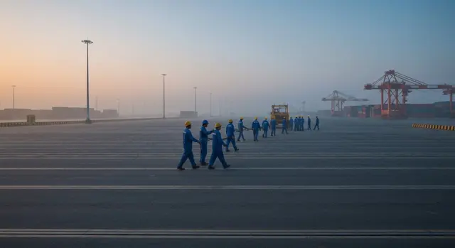 Dazi Trump PMI italiane: container al porto italiano all'alba con tonalità blu-ambra