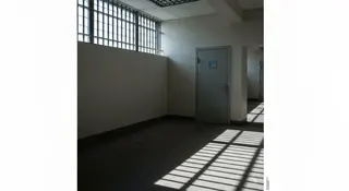 Roggero in carcere: corridoio di un istituto penitenziario con ombre delle sbarre sul pavimento