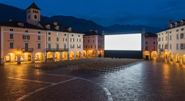 Premi italiani a Locarno: la piazza del festival al crepuscolo con il maxischermo acceso e le sedie vuote