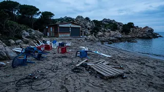Spiaggia di Porto Istana all'alba dopo l'aggressione omofoba a Olbia, sedie rovesciate e cavi sulla sabbia