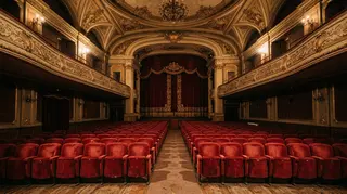Agenzia per il cinema: sala cinematografica storica italiana vuota con sipario chiuso e poltrone rosse