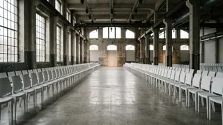 Visitatori italiani in calo alla Fashion Week: sedie vuote in prima fila davanti alla passerella di una sfilata milanese