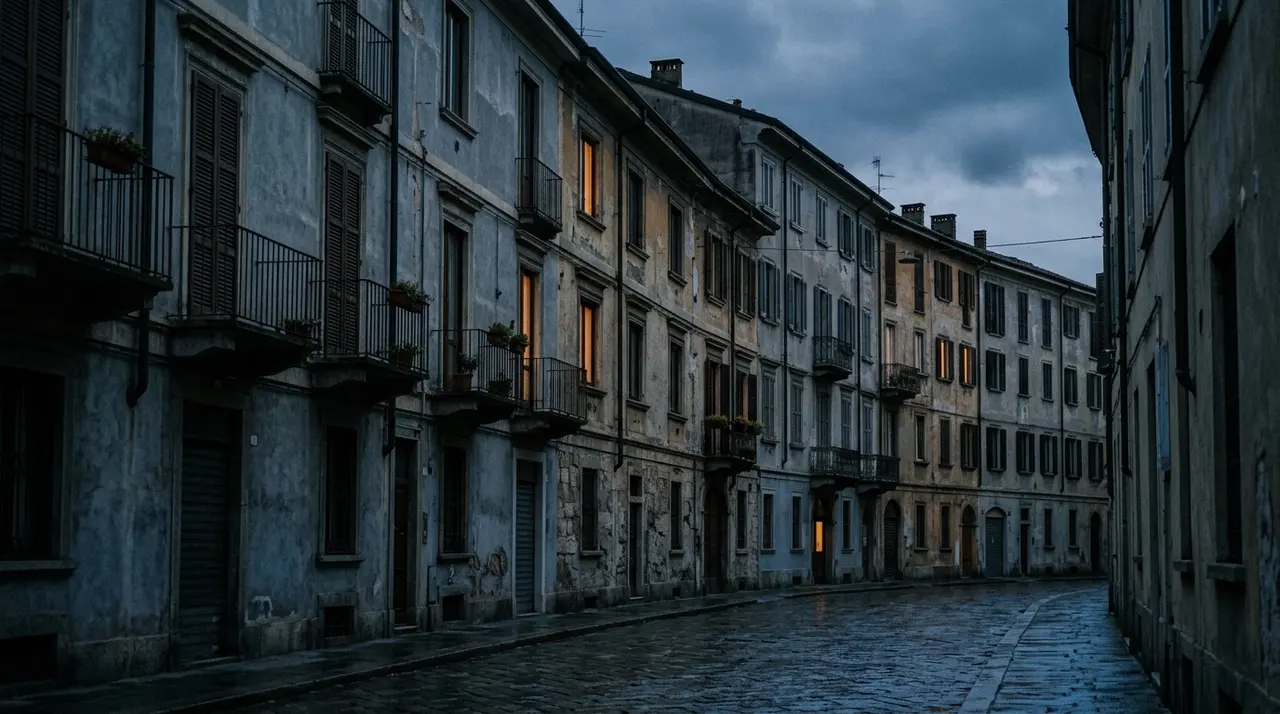 Palazzi residenziali italiani al crepuscolo con poche finestre illuminate, la bolletta elettrica dei clienti vulnerabili sale del 37,3%