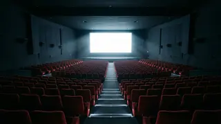 Sala cinematografica vuota con schermo acceso, simbolo degli obblighi di programmazione della fusione Skydance